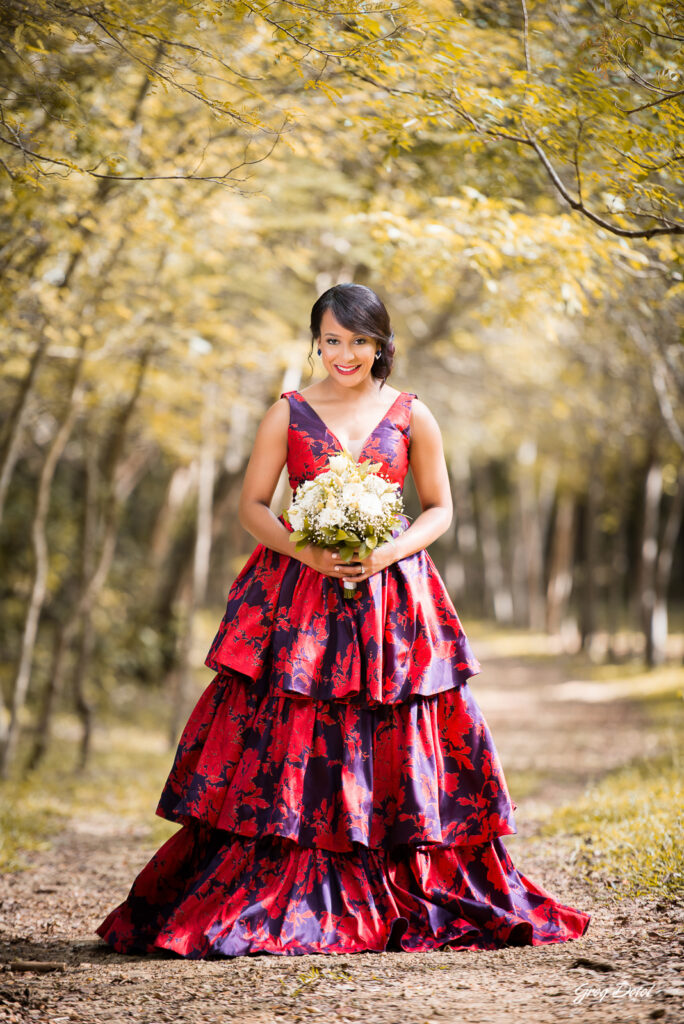 Sesión de fotos pre boda o novios en el Parque Humedales del Ozama en Santo Domingo, República Dominicana por el fotografo dominicano Greg Dotel Photography. Fotos de novios en el parque con traje de novia rojo con flores y traje de caballero.