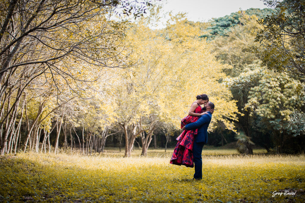 Sesión de fotos pre boda o novios en el Parque Humedales del Ozama en Santo Domingo, República Dominicana por el fotografo dominicano Greg Dotel Photography. Fotos de novios en el parque con traje de novia rojo con flores y traje de caballero.