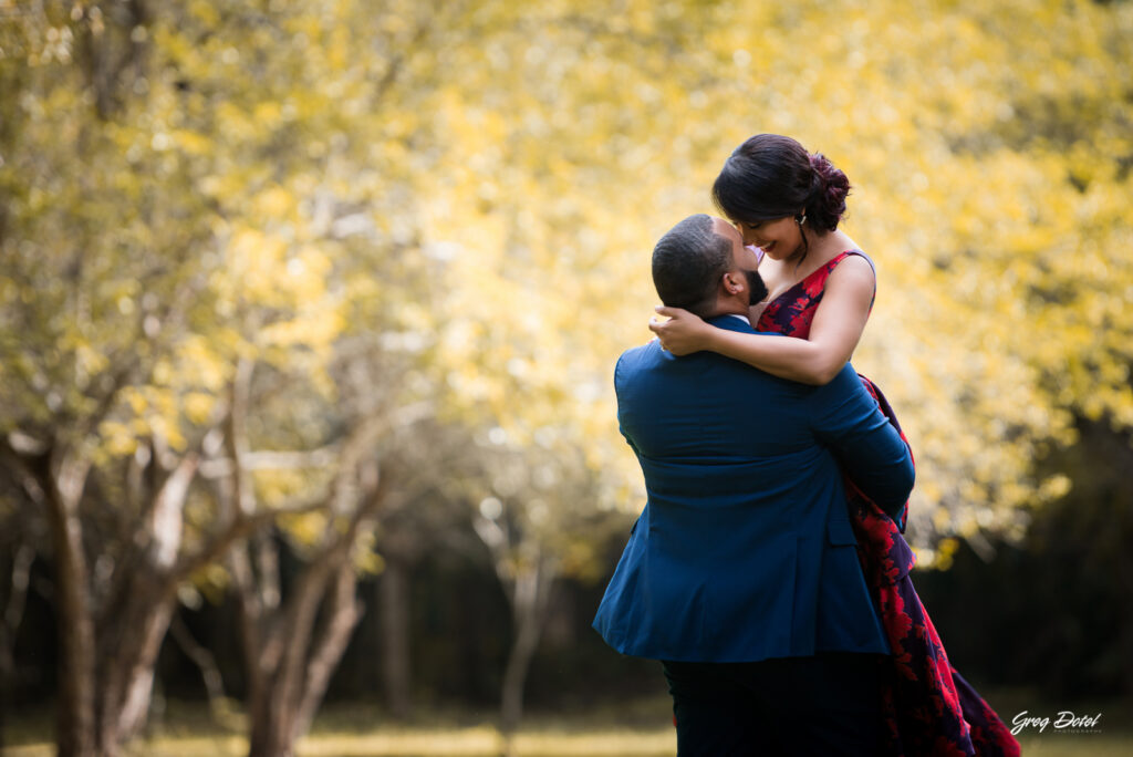 Sesión de fotos pre boda o novios en el Parque Humedales del Ozama en Santo Domingo, República Dominicana por el fotografo dominicano Greg Dotel Photography. Fotos de novios en el parque con traje de novia rojo con flores y traje de caballero.