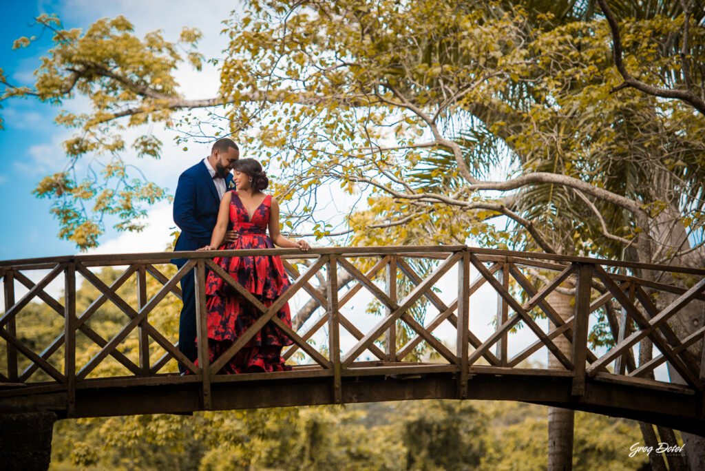 Sesión de fotos pre boda o novios en el Parque Humedales del Ozama en Santo Domingo, República Dominicana por el fotografo dominicano Greg Dotel Photography. Fotos de novios en el parque con traje de novia rojo con flores y traje de caballero.