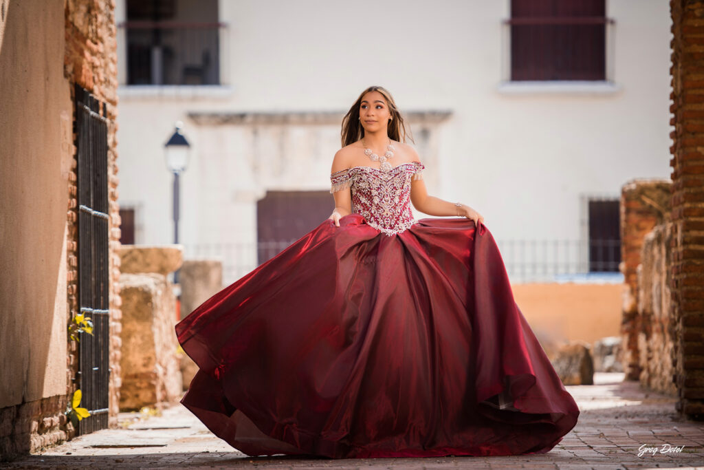 Quinceañera en las Ruinas del Hospital San Nicolas de Bari en la Zona Colonial de Santo Domingo, República Dominicana en su sesión de fotos profesional con elegante vestido rojo de 15 años