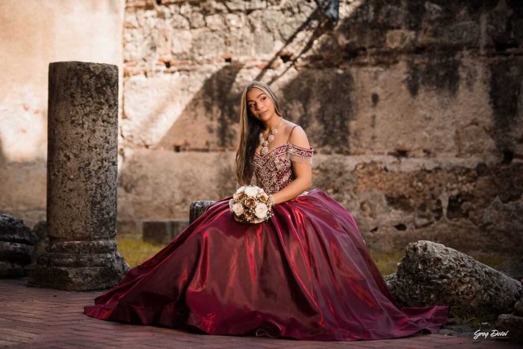 Quinceañera en las Ruinas del Hospital San Nicolas de Bari en la Zona Colonial de Santo Domingo, República Dominicana en su sesión de fotos profesional con elegante vestido rojo de 15 años