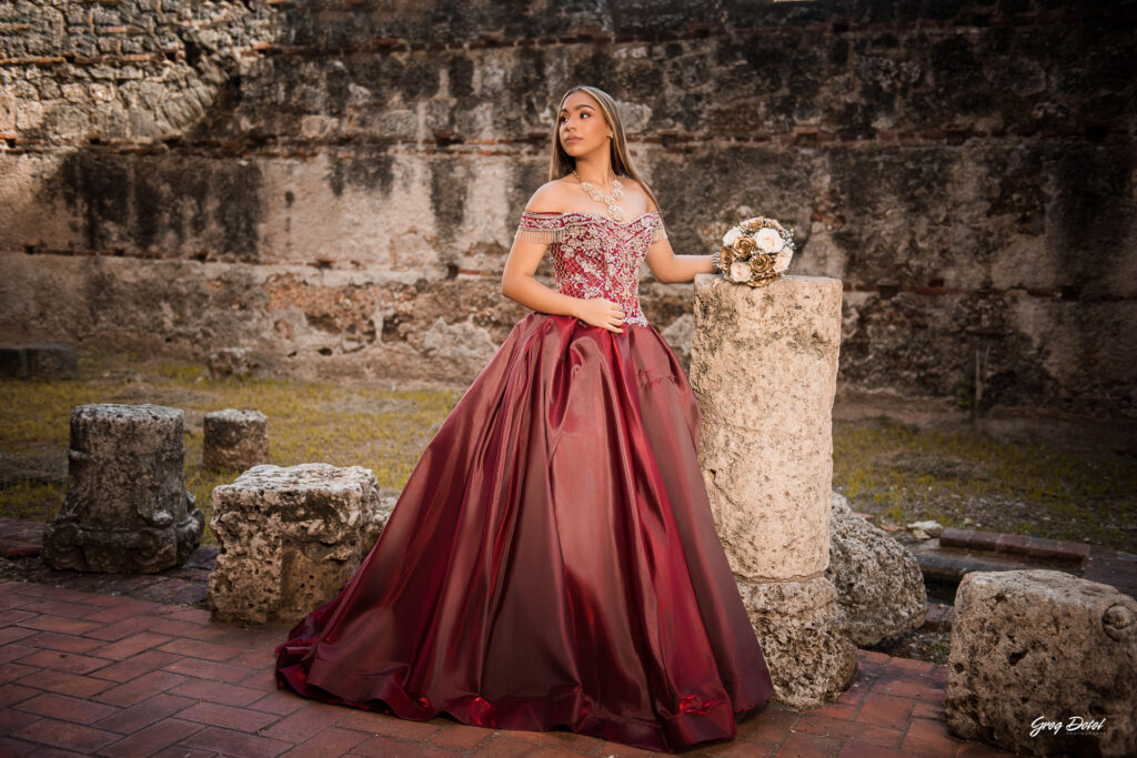 Quinceañera en las Ruinas del Hospital San Nicolas de Bari en la Zona Colonial de Santo Domingo, República Dominicana en su sesión de fotos profesional con elegante vestido rojo de 15 años