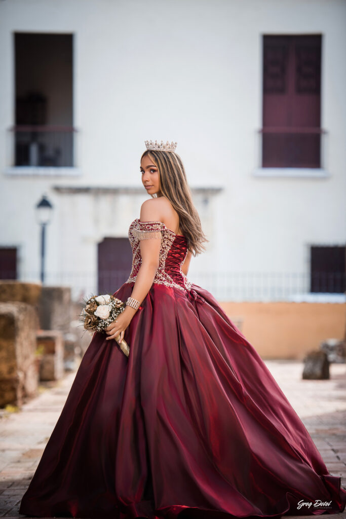Quinceañera en las Ruinas del Hospital San Nicolas de Bari en la Zona Colonial de Santo Domingo, República Dominicana en su sesión de fotos profesional con elegante vestido rojo de 15 años